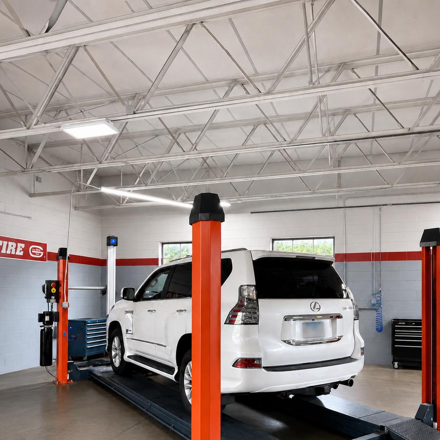 White SUV on an alignment rack with alignment targets mounted to the wheels
